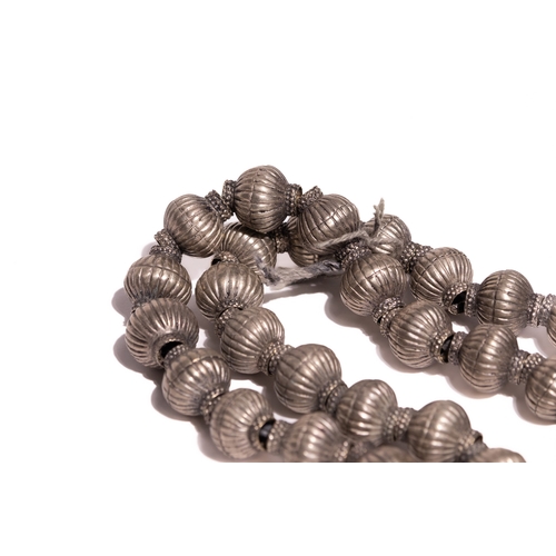 60 - A Tribal White Metal Bead Necklace.

The necklace is composed of a continuous strand of large, hollo... 
