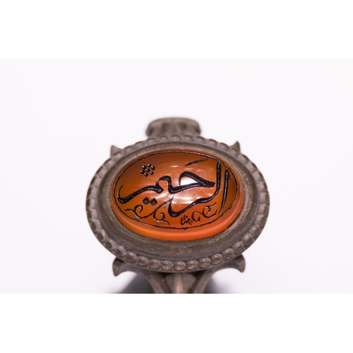 42 - An Islamic Silver Ring Set with an Orange Agate Panel Featuring Arabic Calligraphy.

An Islamic silv... 