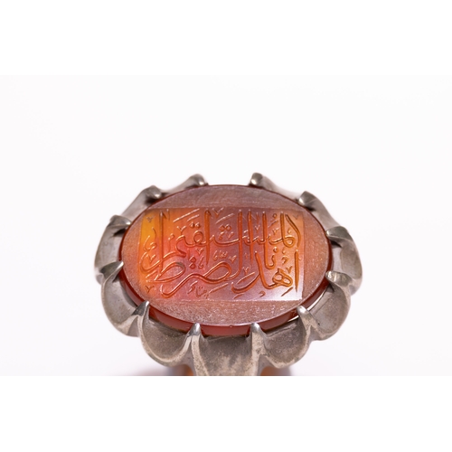 45 - An Islamic Silver Ring Set with a Carved Orange Agate Panel Featuring Arabic Calligraphy.

An Islami... 