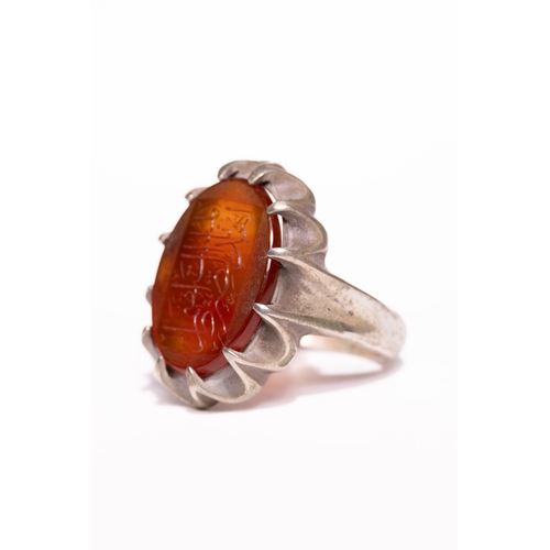 45 - An Islamic Silver Ring Set with a Carved Orange Agate Panel Featuring Arabic Calligraphy.

An Islami... 