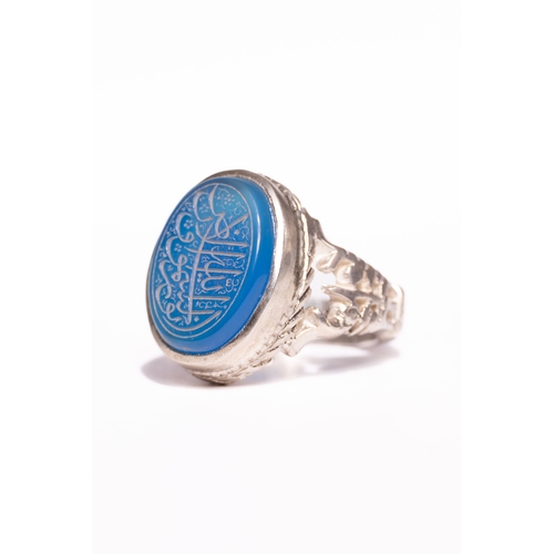 46 - An Islamic Silver Ring Set with a Carved Blue Agate Panel Featuring Arabic Calligraphy.

An Islamic ... 