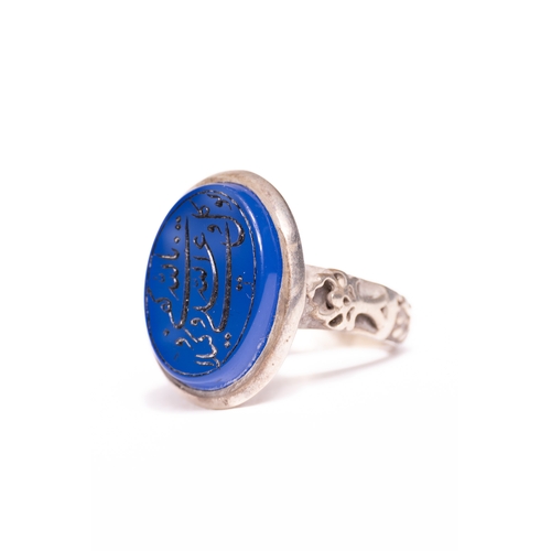 50 - An Islamic Silver Ring Set with a Carved Blue Agate Panel Featuring Arabic Inscription.

An Islamic ... 