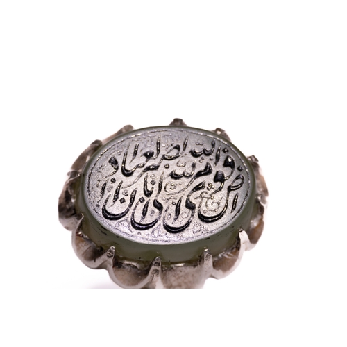 51 - An Islamic Silver Ring Set with a Carved Pale Green Agate Panel Featuring Arabic Inscription.

An Is... 