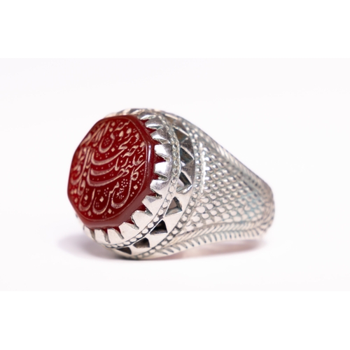 52 - An Islamic Silver Ring Set with a Carved Red Agate Panel Featuring Arabic Inscription.

An Islamic s... 