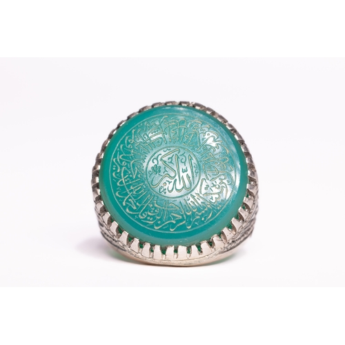 53 - An Islamic Silver Ring Set with a Carved Green Agate Panel Featuring Arabic Inscription.

An Islamic... 