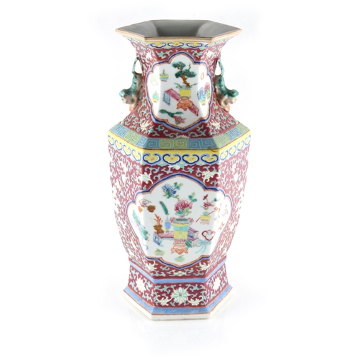 259 - Property of a lady - a late 19th century Chinese ruby ground famille rose hexagonal vase, painted wi... 