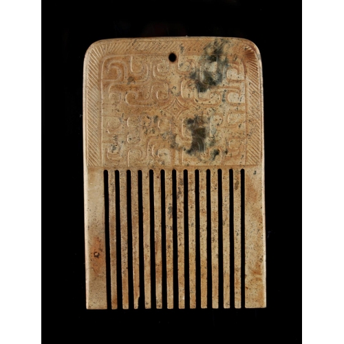 284 - A Chinese archaistic jade comb, with carved panels, 3.15ins. (8cms.) long (see illustration).