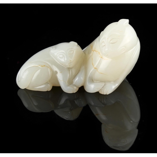 476 - A Chinese carved white jade model of a recumbent lion & cub, 2.6ins. (6.6cms.) long (see illustratio... 