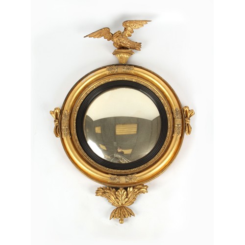 387 - A 19th century carved giltwood framed convex mirror with eagle cresting & acanthus below, 44.5ins. (... 