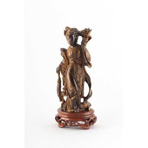 184 - Property of a deceased estate - a Chinese carved tiger's eye figure of Guanyin, on fitted wooden sta... 