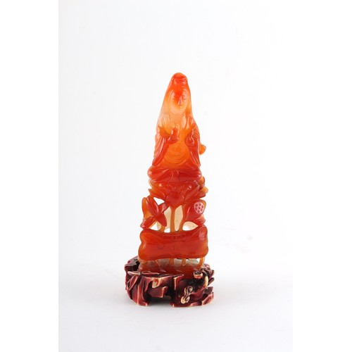 203 - Property of a gentleman - a Chinese finely carved carnelian agate figure of Guanyin seated on lotus ... 