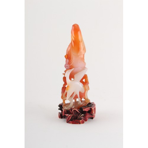 203 - Property of a gentleman - a Chinese finely carved carnelian agate figure of Guanyin seated on lotus ... 