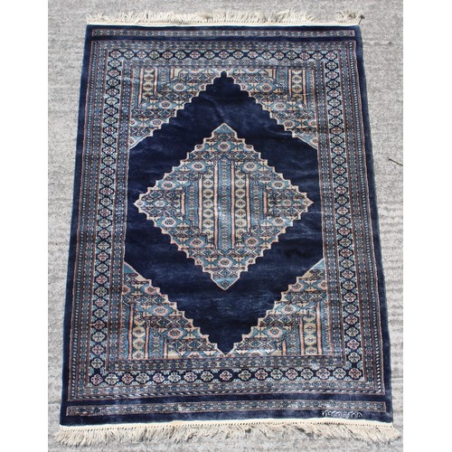 359 - Property of a gentleman - a good quality hand knotted part silk rug, Pakistan, with navy ground, sig... 