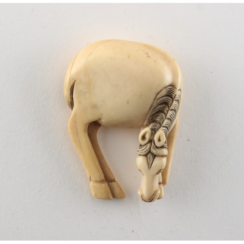 224 - Property of a gentleman - a Japanese carved ivory netsuke modelled as a grazing horse, 18th / 19th c... 