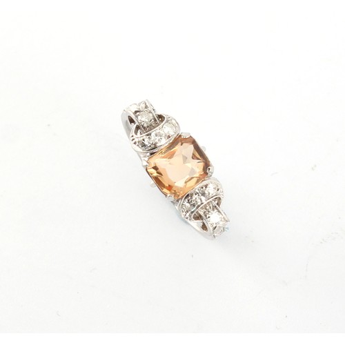 6 - An early 20th century white metal (probably platinum) topaz & diamond ring, with ornately pierced mi... 