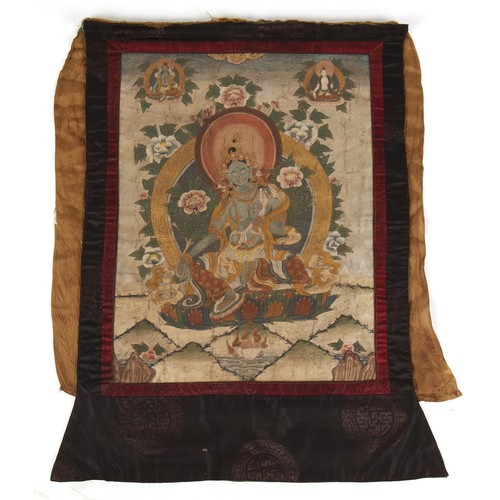 126 - A 19th century thankga painted on linen and depicting the Green Tara, the painting 21.25 by 16.15ins... 