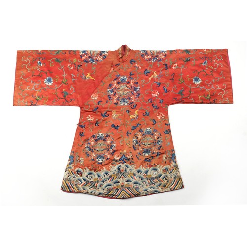 195 - A Chinese embroidered silk long robe with brick red ground, late 19th century.