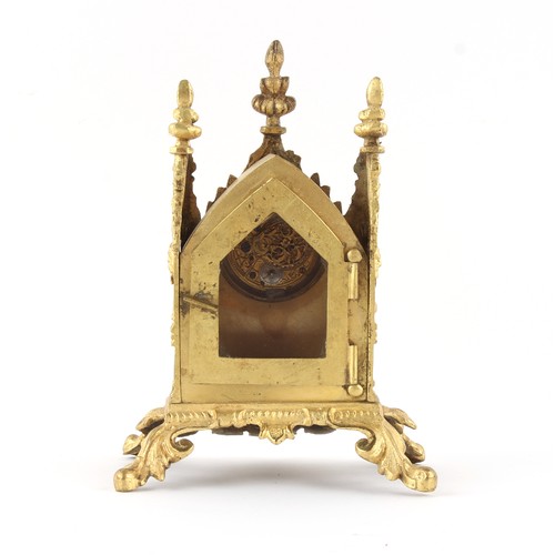 252 - The Henry & Tricia Byrom Collection - a small gilt metal gothic cased mantel clock timepiece, the po... 