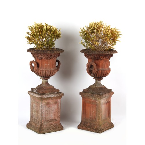 532 - Property of a gentleman - a pair of well weathered terracotta garden urns on separate plinths, with ... 