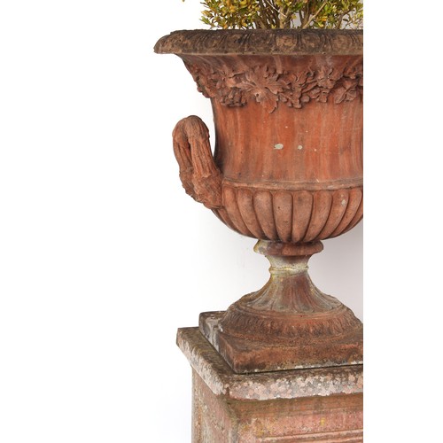 532 - Property of a gentleman - a pair of well weathered terracotta garden urns on separate plinths, with ... 