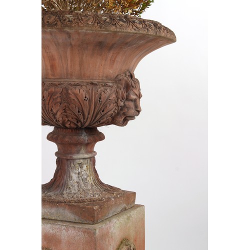 533 - Property of a gentleman - a pair of well weathered terracotta garden urns on separate plinths, with ... 