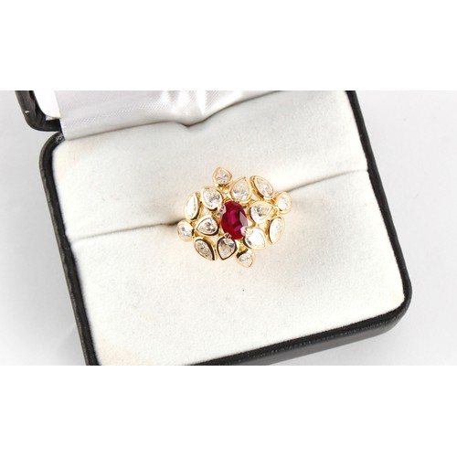 117 - An 18ct yellow gold ruby & diamond floral cluster ring, the oval cushion cut ruby weighing approxima... 