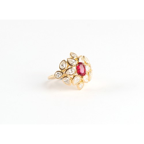 117 - An 18ct yellow gold ruby & diamond floral cluster ring, the oval cushion cut ruby weighing approxima... 