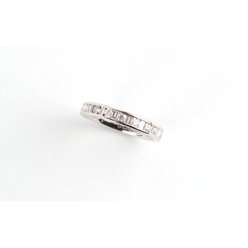 111 - An unmarked white gold diamond eternity ring, set with round brilliant cut diamonds alternating with... 