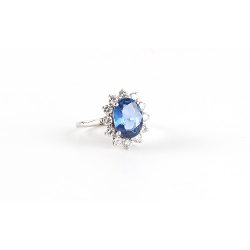 113 - An unmarked white gold sapphire & diamond oval cluster ring, the oval cushion cut sapphire weighing ... 