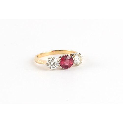 128 - An 18ct yellow gold ruby & diamond three stone ring, the centre round cut ruby weighing approximatel... 