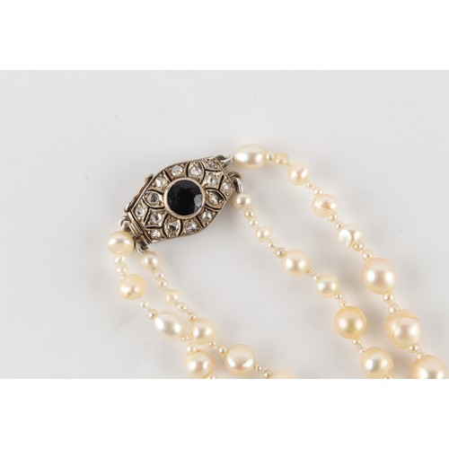 96 - A natural saltwater pearl two strand necklace, the largest barrel shaped pearl measuring approximate... 