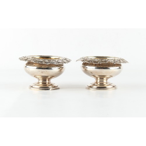 262 - Property of a gentleman - a pair of William IV silver circular pedestal salts with vine borders & gi... 