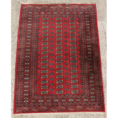 210 - Property of a gentleman - a Turkoman design hand-knotted wool rug with red field, 73 by 50ins. (186 ... 