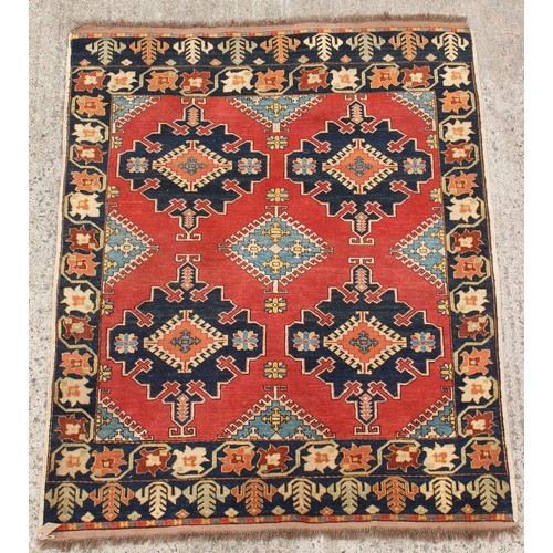 212 - Property of a gentleman - a Caucasian design hand-knotted wool rug with red field, 68 by 55ins. (173... 