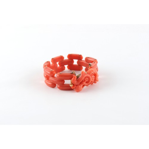 69 - A coral link bracelet with carved bird & snake clasp, with safety chain, approximately 34.4 grams.