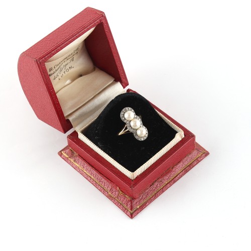 255 - Property of a lady - an 18ct gold ring set with three pearls within a border of diamonds, the pearls... 