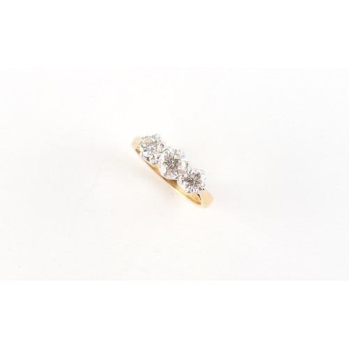 26 - An 18ct yellow gold diamond three stone ring, the estimated total diamond weight 1.05 carats, size I... 