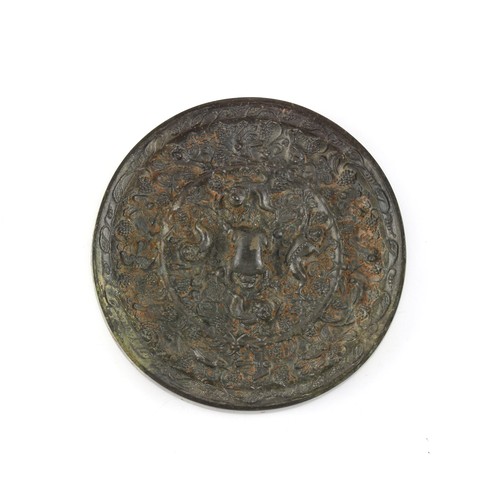 187 - Property of a lady - a Chinese bronze mirror, in the Tang style, 4.4ins. (11.2cms.) diameter.