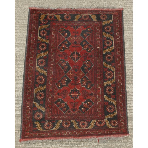 207 - Property of a gentleman - an Afghan hand-knotted wool rug, 57 by 41ins. (145 by 104cms.).