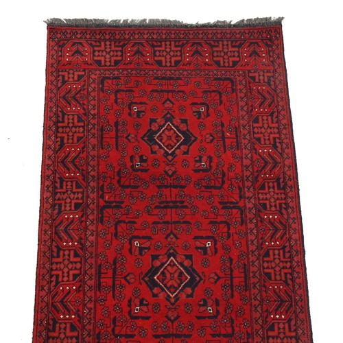 208 - Property of a deceased estate - an Afghan hand knotted wool runner, with red ground, 150 by 31ins. (... 