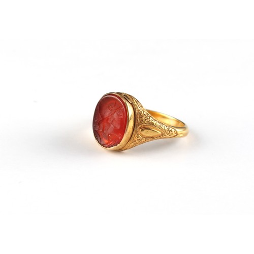 102 - An 18ct gold carved carnelian agate intaglio signet ring, the oval intaglio depicting a classical ma... 