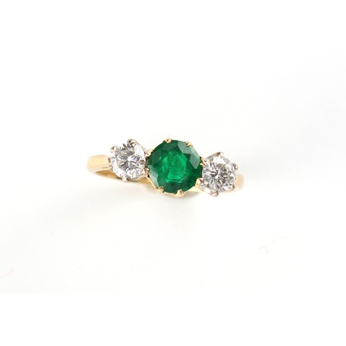 139 - An 18ct yellow gold emerald & diamond three stone ring, the round cut emerald weighing approximately... 