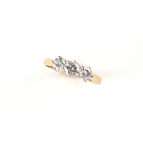 160 - An 18ct yellow gold diamond three stone ring, the estimated total diamond weight 0.77 carat, size M.