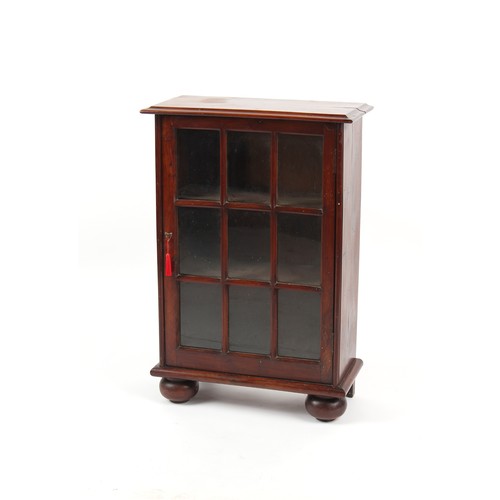 254 - Property of a lady - an early 19th century solid yew wood glazed cabinet, with bun feet, 23.25ins. (... 