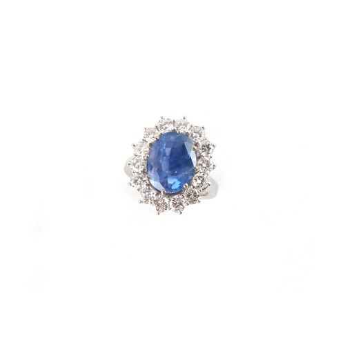 125 - An 18ct white gold sapphire & diamond oval cluster ring, the large oval cushion cut cornflower blue ... 