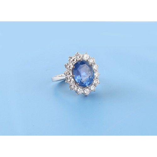 125 - An 18ct white gold sapphire & diamond oval cluster ring, the large oval cushion cut cornflower blue ... 