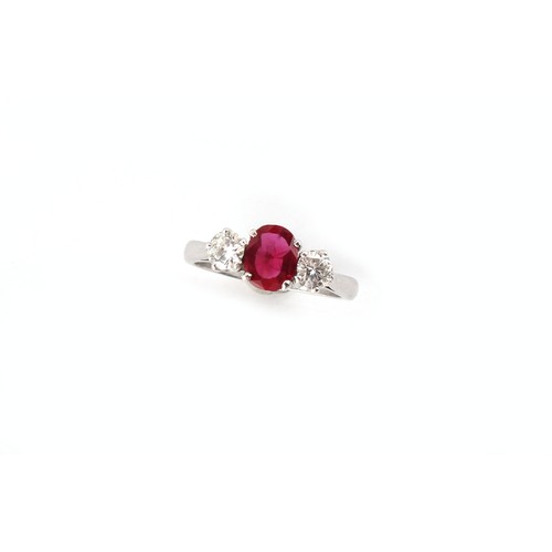 74 - A platinum ruby & diamond three stone ring, the centre oval cushion cut ruby weighing approximately ... 