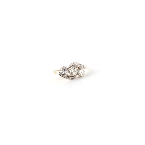 109 - An unmarked yellow gold diamond crossover ring, the centre stone approximately 0.39 carat, size K.