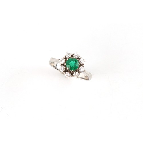 121 - An 18ct white gold emerald & diamond cluster ring, the round cut emerald weighing approximately 0.59... 