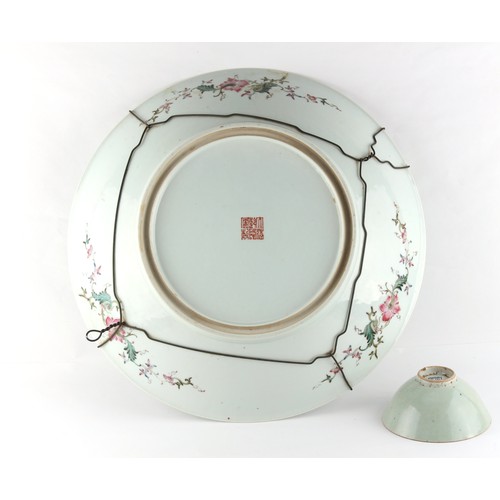 259 - A large Chinese famille rose charger or shallow dish, painted with a large centre landscape and thre... 